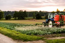 Tractor spraying pesticides on cabbage field. agriculture concept