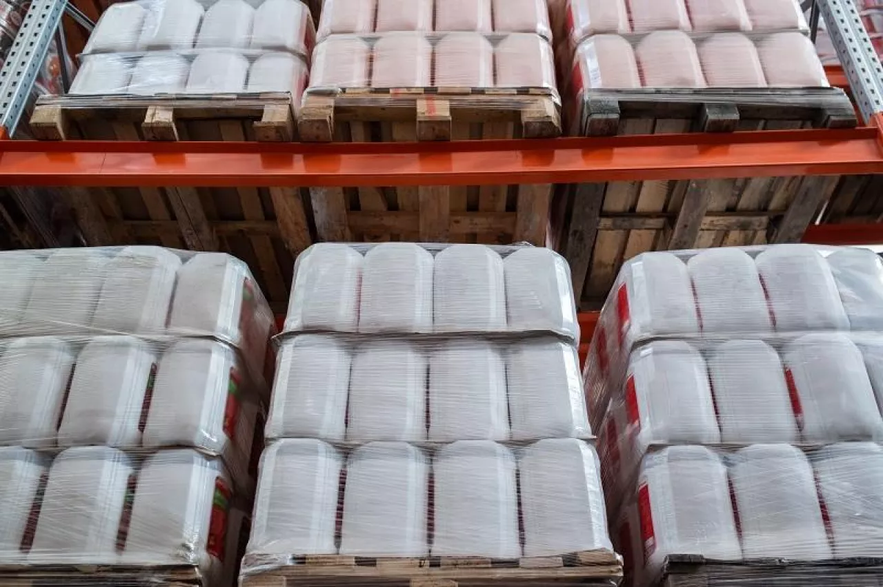 Rows of packed plastic cisterns with liquid goods in storage room