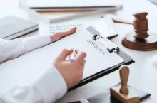 cropped view of woman holding pen near document with immigration lettering