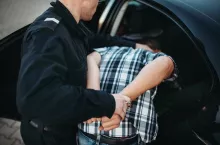 Police officer put the intruder into the car. Cop at the work. Law protection concept, professional safety control