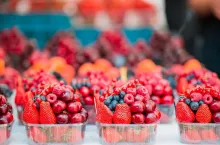 Berries fruits at a marketplace. Blueberries, raspberries, strawberries, cherries and blackberries on the market.