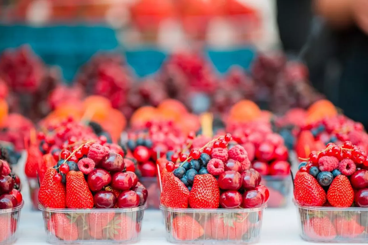 Berries fruits at a marketplace. Blueberries, raspberries, strawberries, cherries and blackberries on the market.