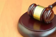 Justice mallet on wooden desk in a courtroom during a judicial trial. Law concept and empty copy space. Judge hammer