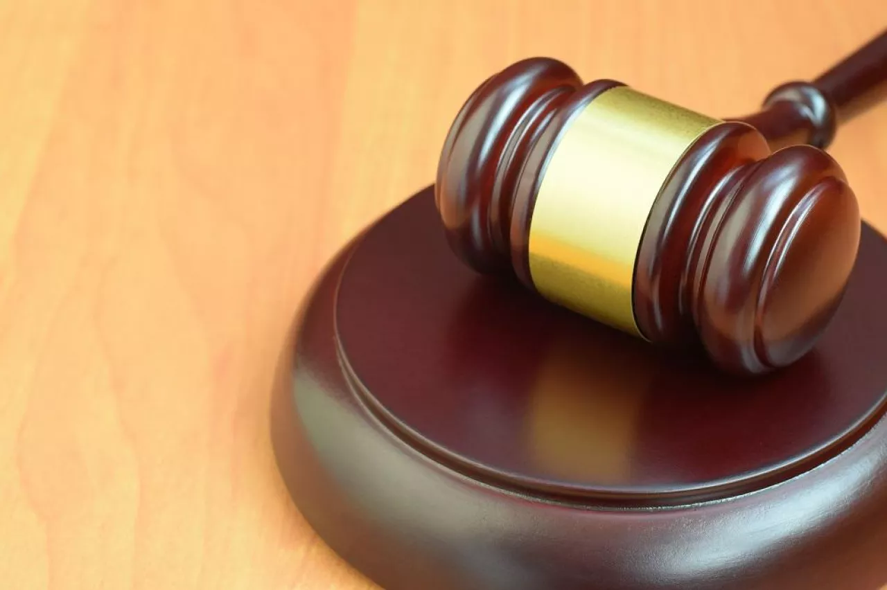 Justice mallet on wooden desk in a courtroom during a judicial trial. Law concept and empty copy space. Judge hammer